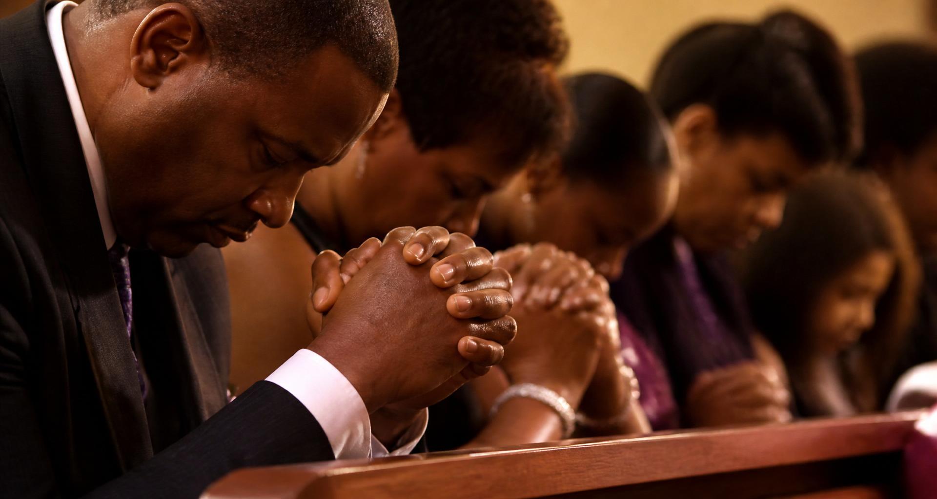 African American people praying together